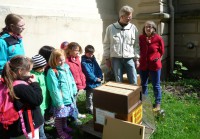 Hortkinder und Bienenpatin Dr. Regina Hanemann an der offenen Lehrbeute/Patenbeute