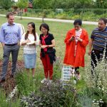 Chinesische Delegation im Bamberger Bienengarten vor Kräuter-Schaubeet