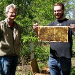 Lehramtsanwärter mit Bienenwabe am Lehrbienenstand "Fünferlessteg"