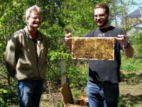 Lehramtsanwärter mit Bienenwabe am Lehrbienenstand "Fünferlessteg"