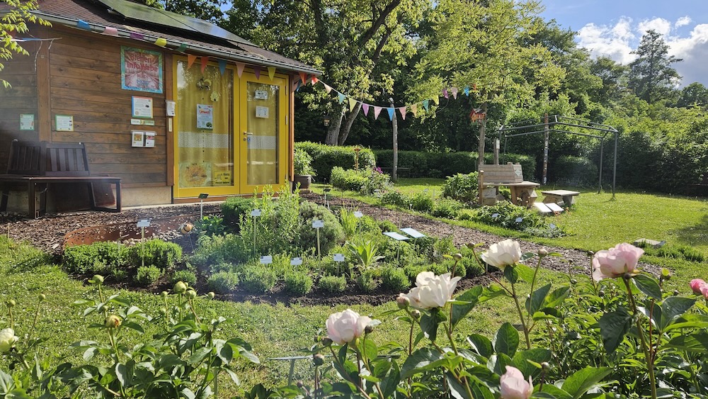 Bienen-InfoWabe mit Pfingstrosenbeet und Kräuterbeet im Bamberger Bienengarten